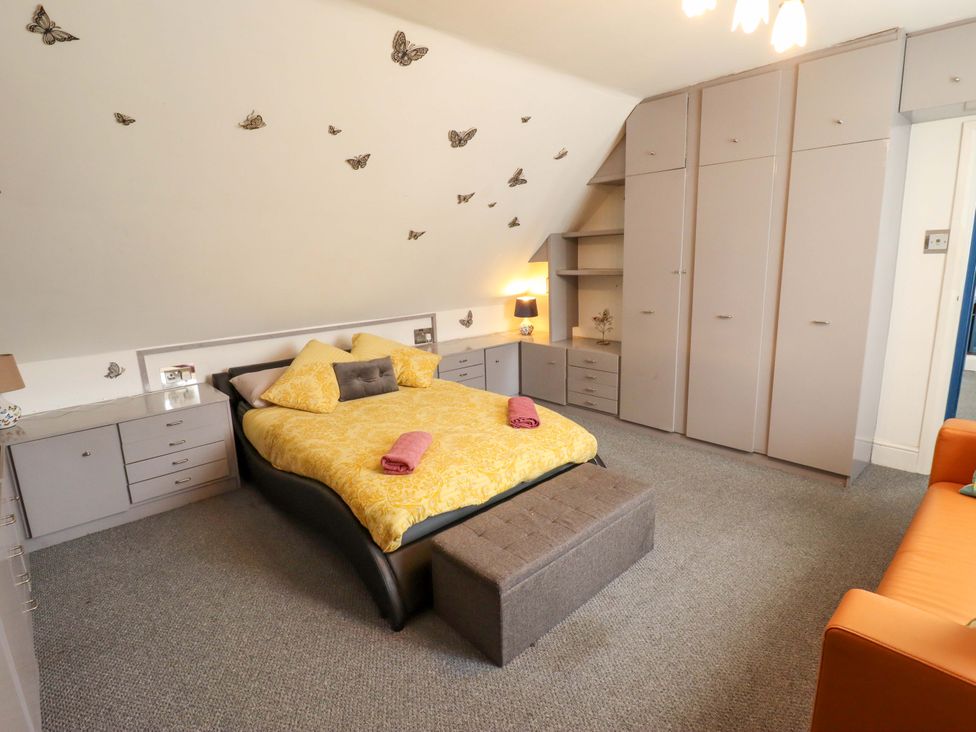 A bedroom with a bed, dresser, and wardrobe at Peartree Cottage 