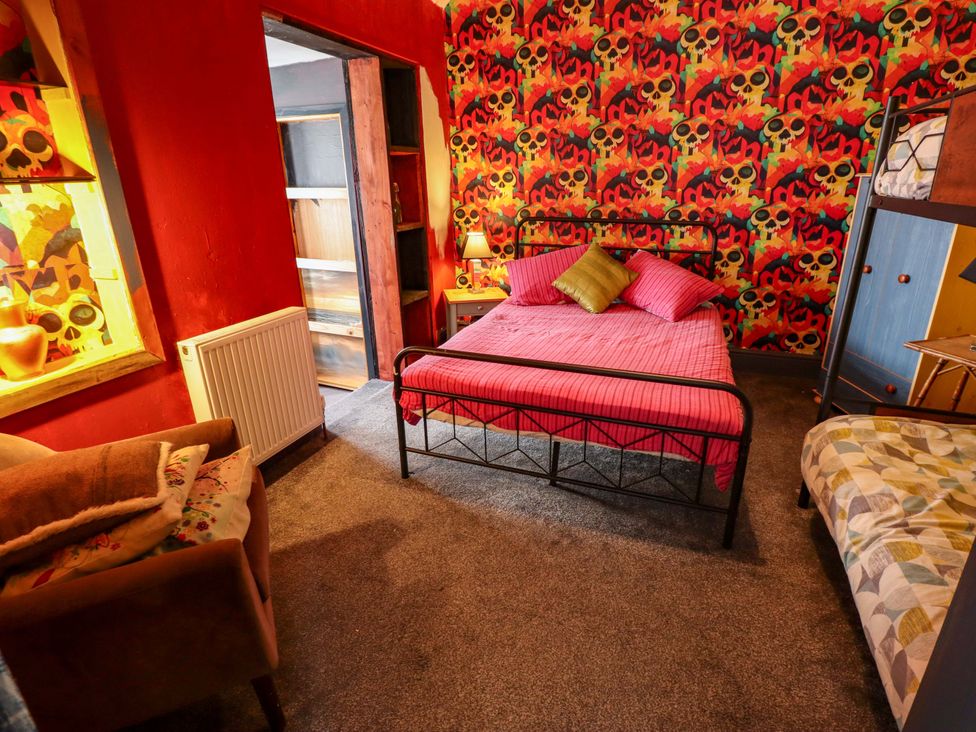 A bedroom with a bed and a lamp at Peartree Cottage