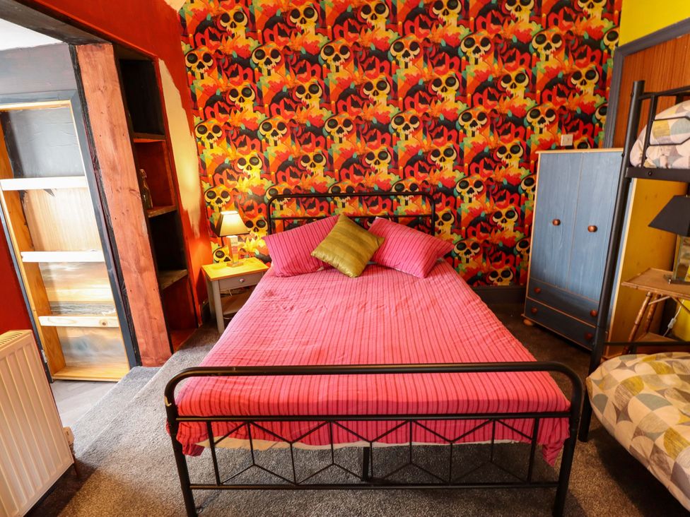 A bedroom with a bed and wardrobe at Peartree Cottage