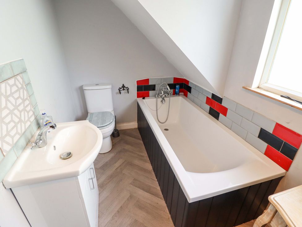 A bathroom with a sink, toilet, and bathtub at Peartree Cottage