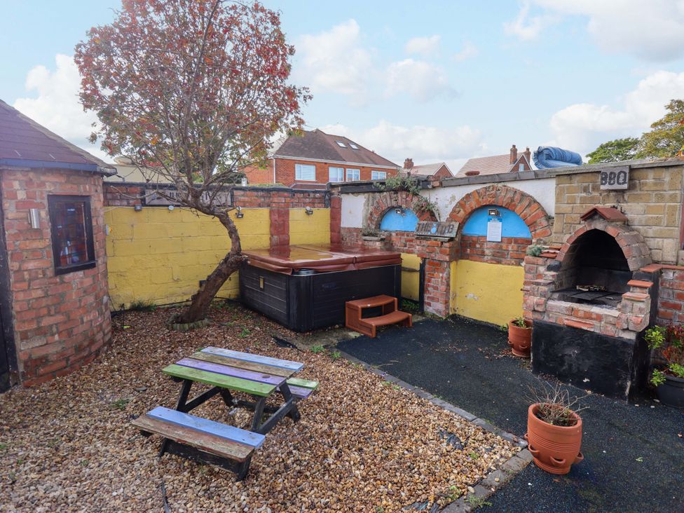 A garden with a hot tub and a barbecue at Peartree Cottage 