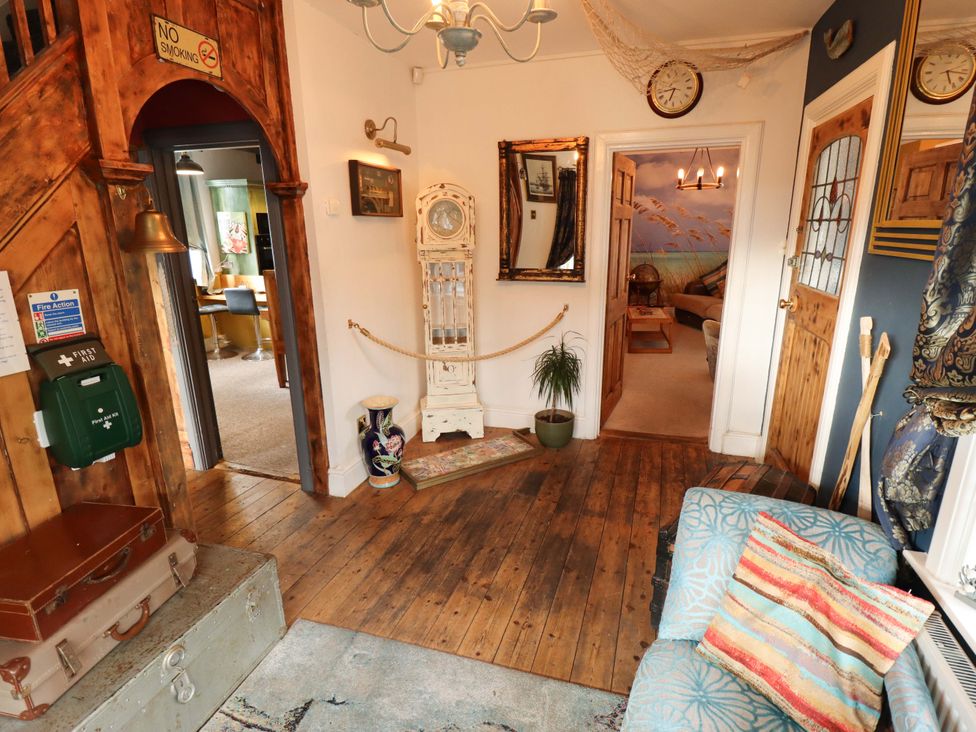 A hallway with a clock, mirror, and sofa at Telford Lodge in Skegness