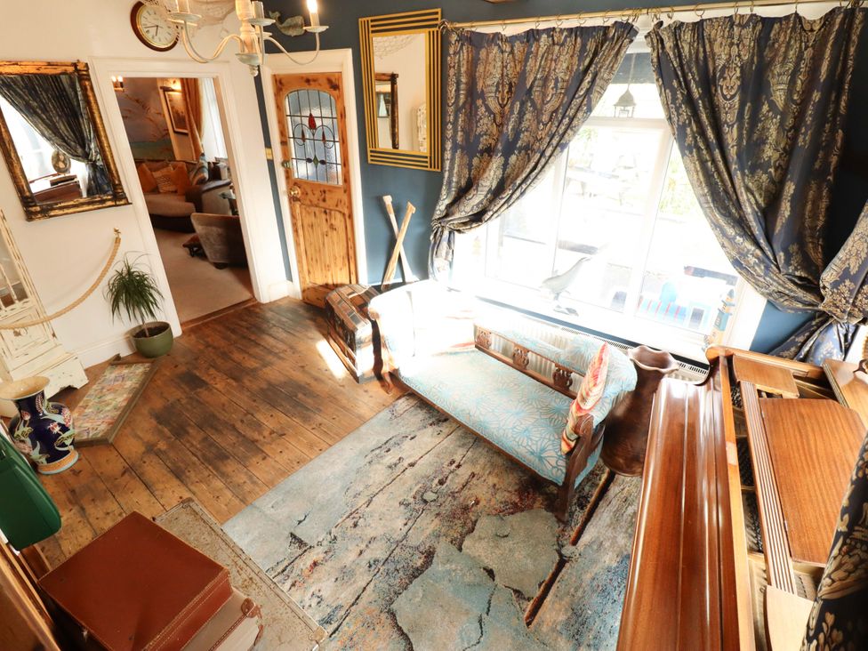 A living room with a sofa and piano at Telford Lodge in Skegness