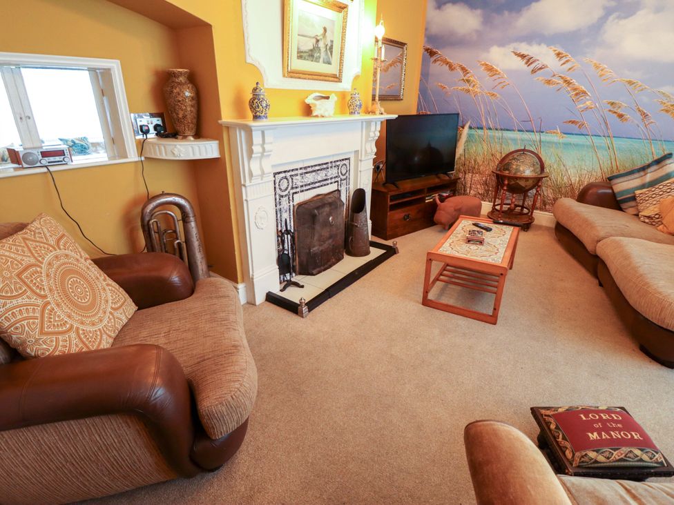 A living room with a fireplace and television at Telford Lodge in Skegness