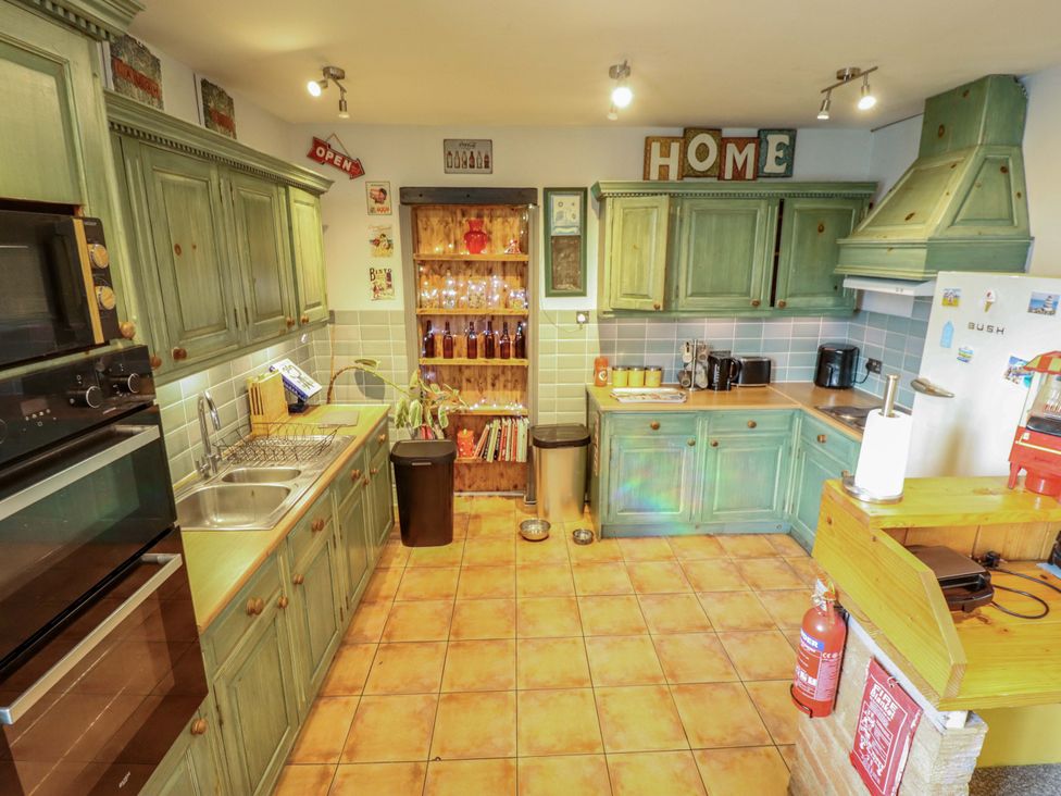 A kitchen with cabinets, sink, and appliances at Telford Lodge in Skegness