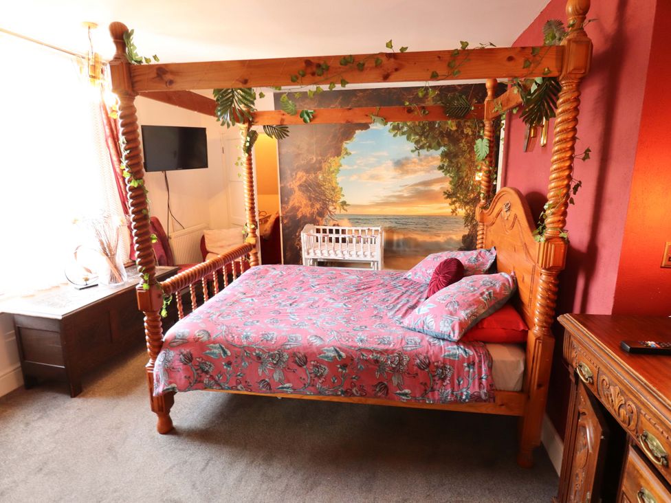 A bedroom with a four-poster bed and a TV at Telford Lodge in Skegness