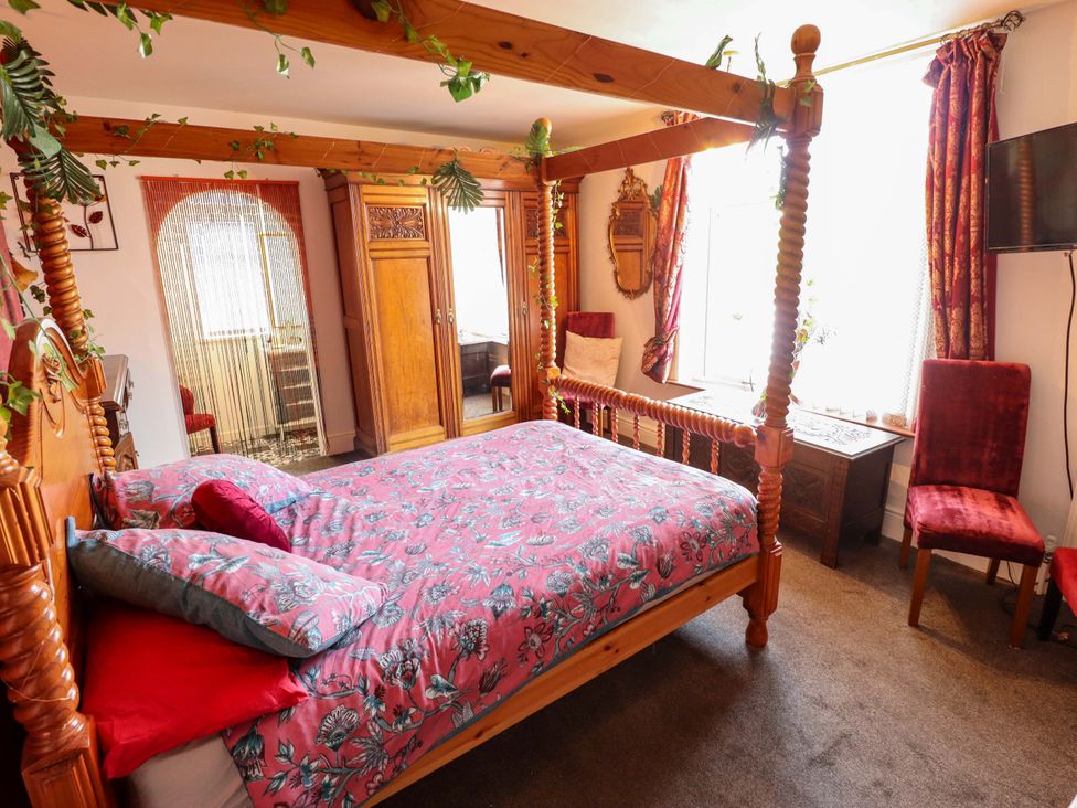 A bedroom with a four-poster bed and wooden furniture at Telford Lodge Skegness