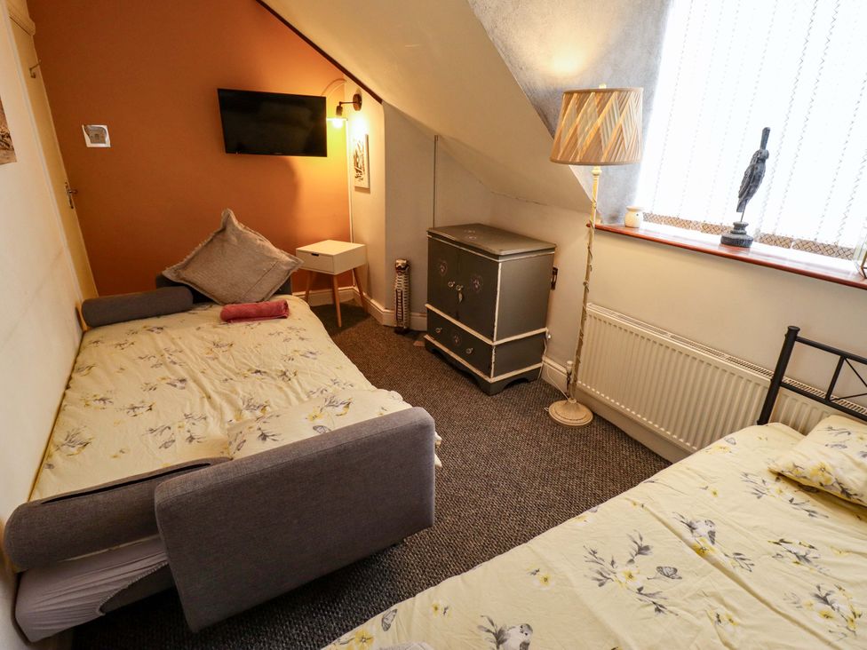A bedroom with two beds and a television at Telford Lodge in Skegness