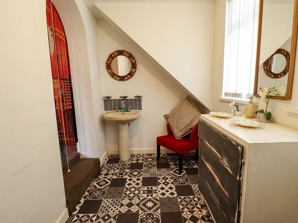 A bathroom with a sink and red chair at Telford Lodge Skegness