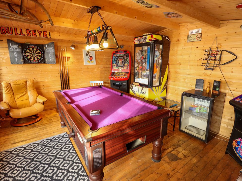 A game room with a pool table and arcade machines at Telford Lodge in Skegness