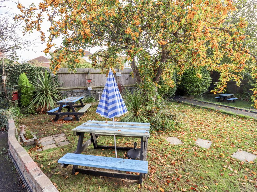 A garden with picnic table and umbrella at Telford Lodge in Skegness
