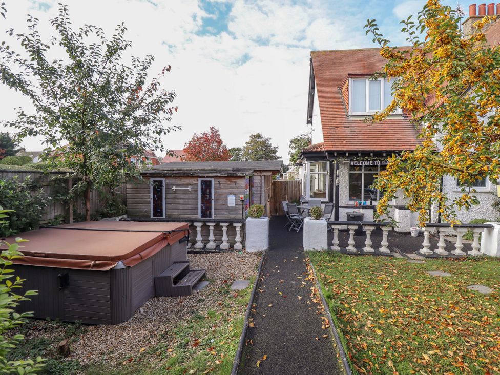 An outdoor area with a hot tub and garden seating at Telford Lodge in Skegness