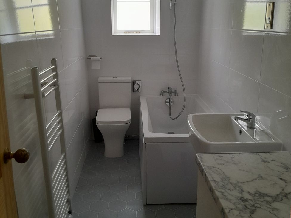 A bathroom with a toilet bathtub with shower sink and marble countertop at Magdala in Peak Dale near Buxton