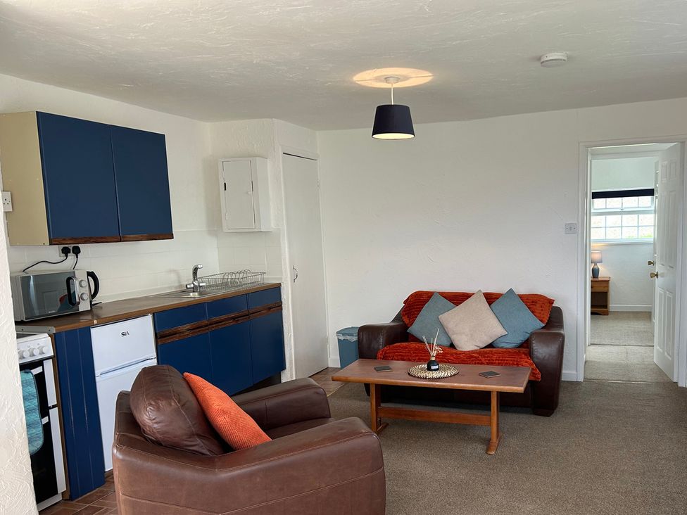 A living room with a sofa and coffee table at Min Y Mor Llanystumdwy near Criccieth