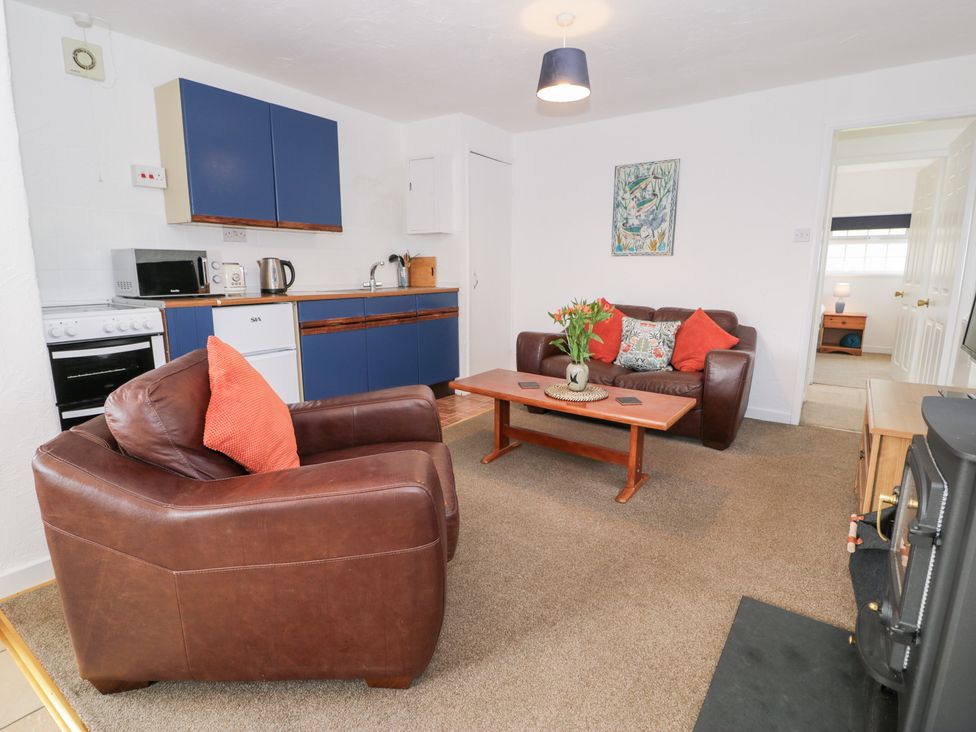 A living room with sofa and coffee table at Min Y Mor in Llanystumdwy near Criccieth