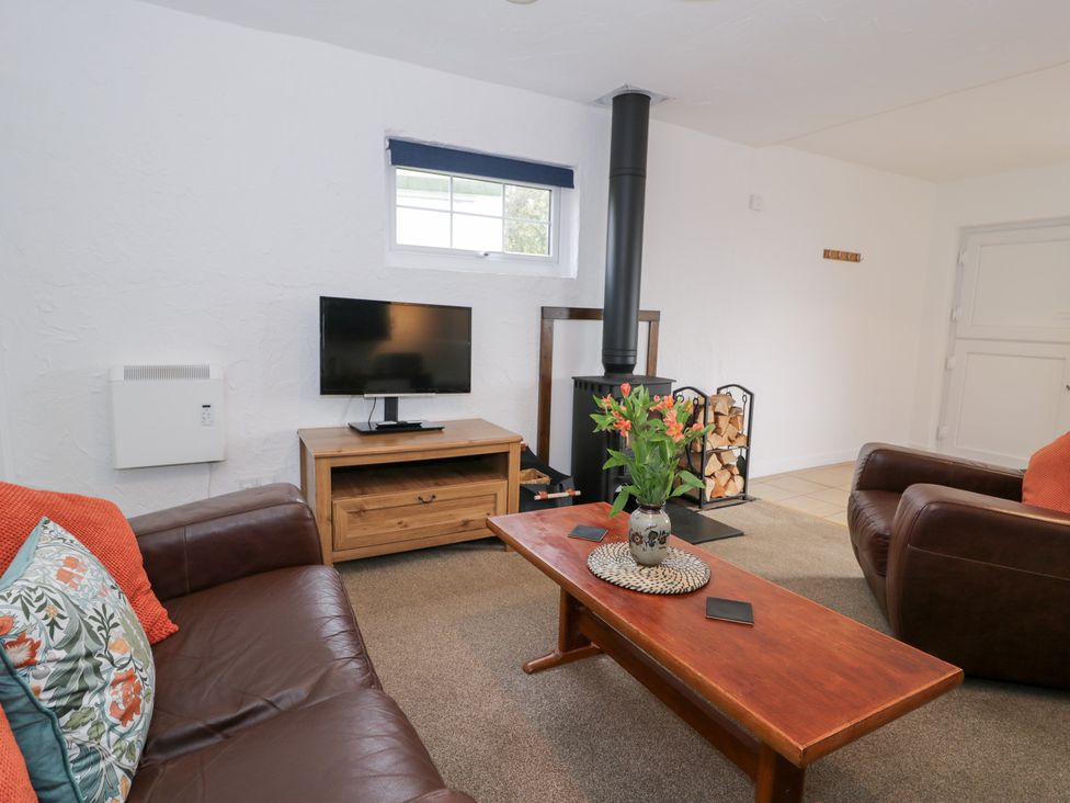 A living room with a television and fireplace at Min Y Mor Llanystumdwy near Criccieth