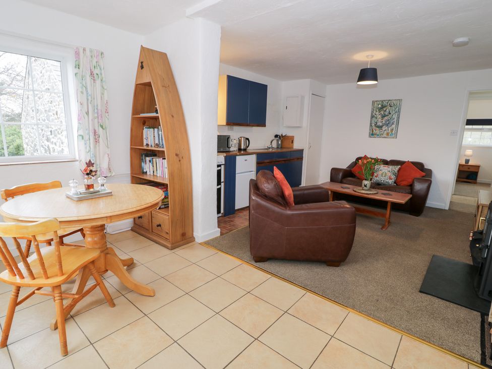A living room with a sofa table and bookshelf at Min Y Mor in Llanystumdwy near Criccieth