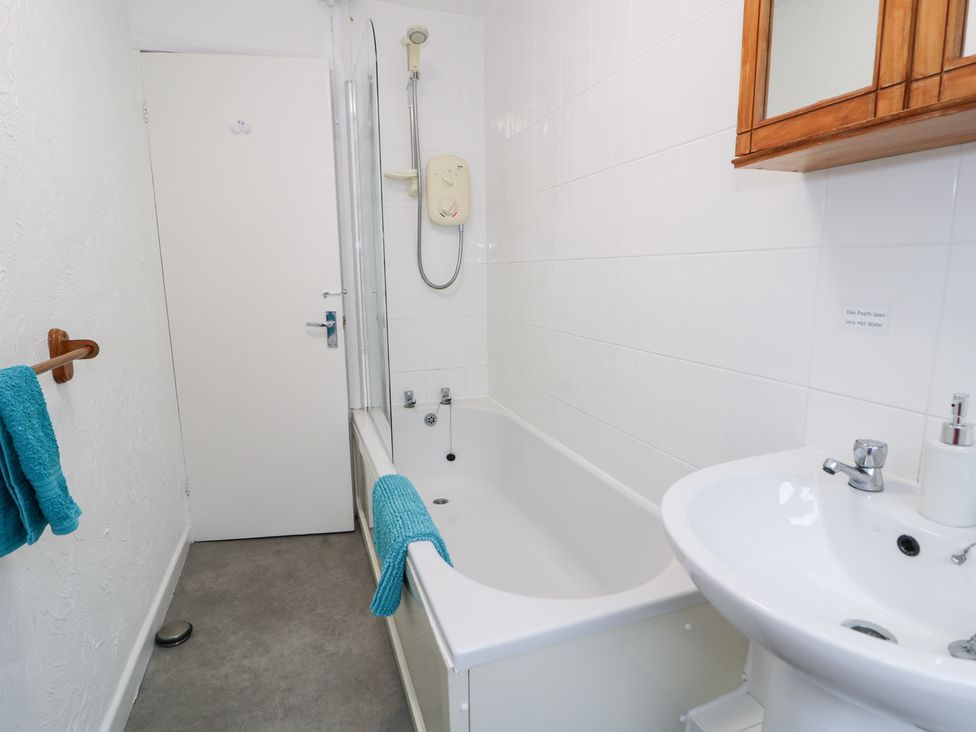 A bathroom featuring a bathtub, sink, and shower at Min Y Mor in Llanystumdwy near Criccieth