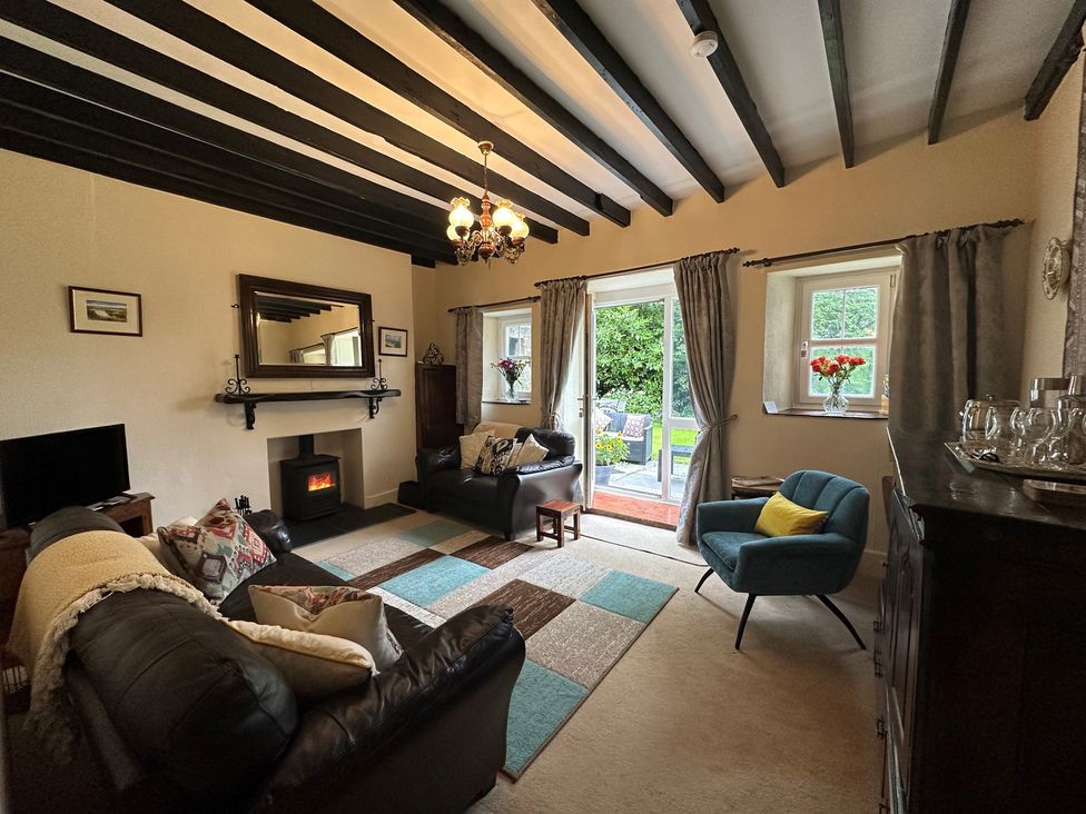 A living room with a sofa, coffee table and fireplace at Parke Cottage Henllan Amgoed near Whitland