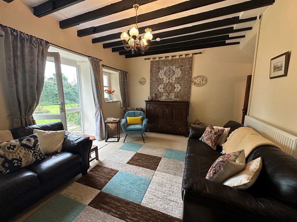 A living room with a sofa and chair at Parke Cottage in Henllan Amgoed near Whitland