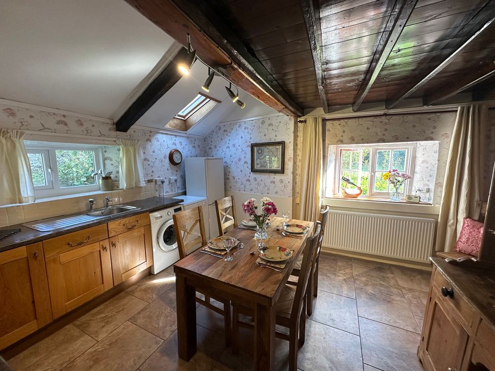 A kitchen with a dining table and chairs at Parke Cottage Henllan Amgoed near Whitland