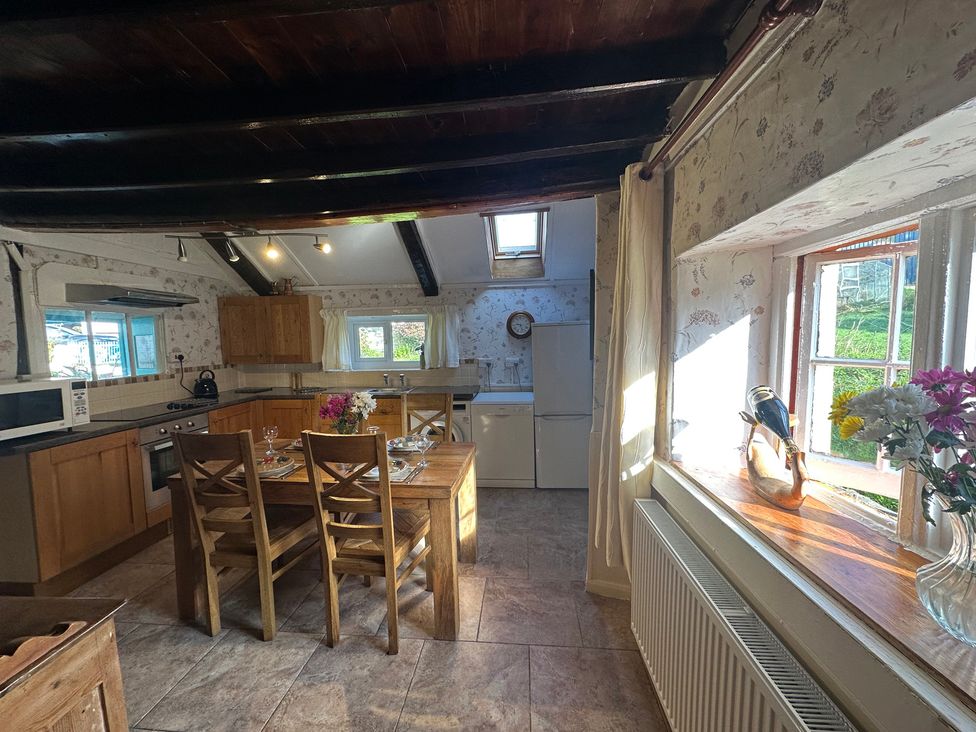 A kitchen with a dining table and chairs at Parke Cottage in Henllan Amgoed near Whitland