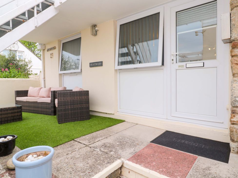 An outdoor area with a sofa and table at Driftwood in Marazion