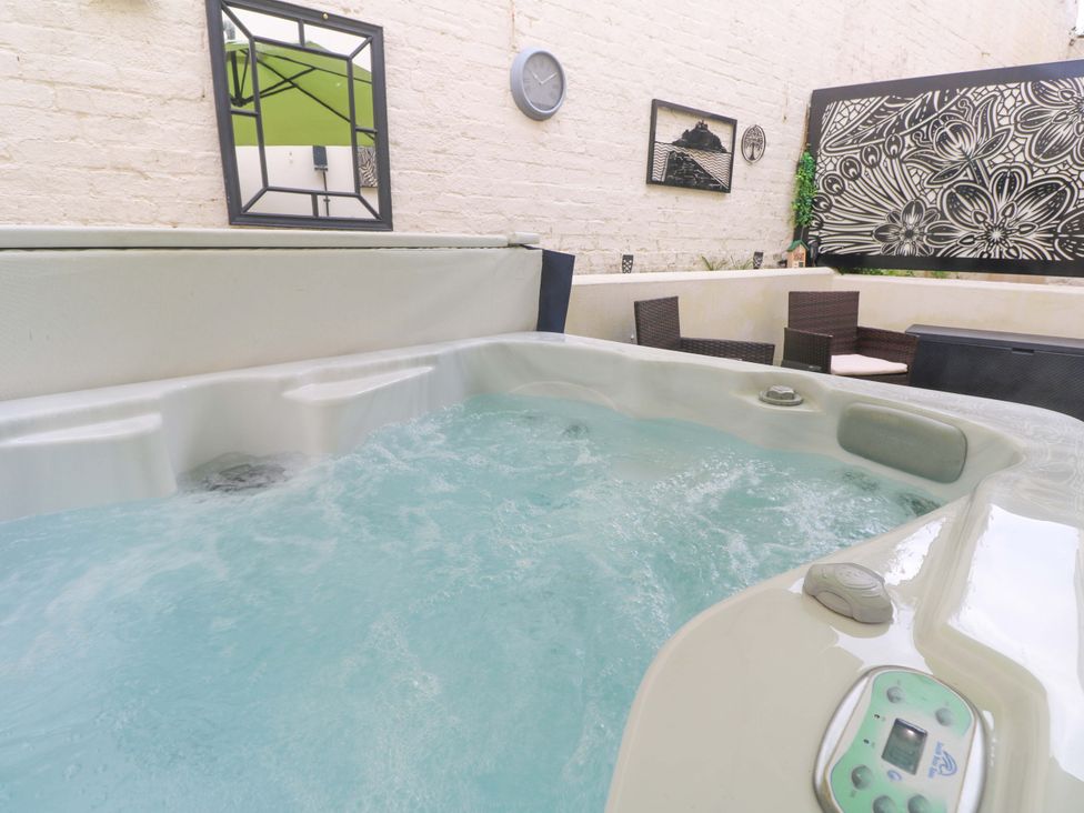 A hot tub with seating area and decorative features at Driftwood in Marazion