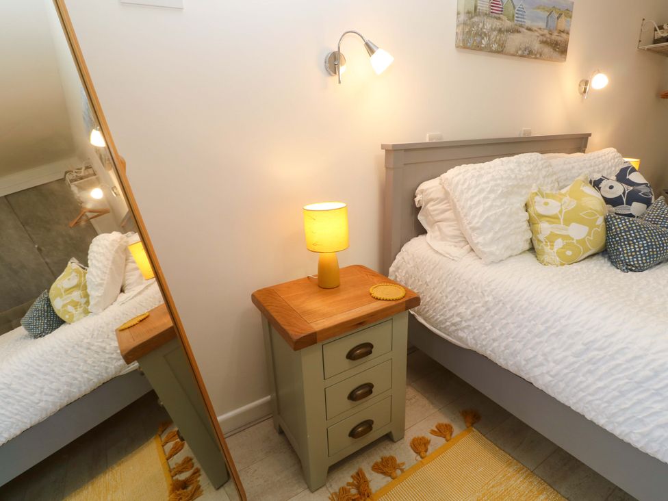 A bedroom with a bed and nightstand at Driftwood in Marazion