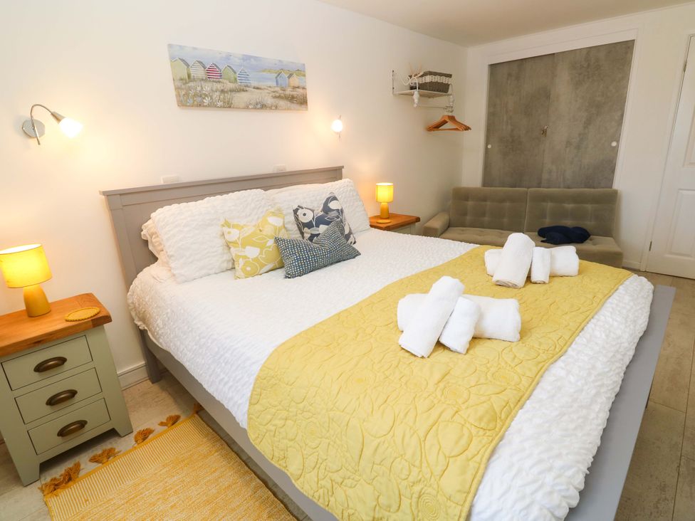 A bedroom with a double bed and nightstand at Driftwood in Marazion