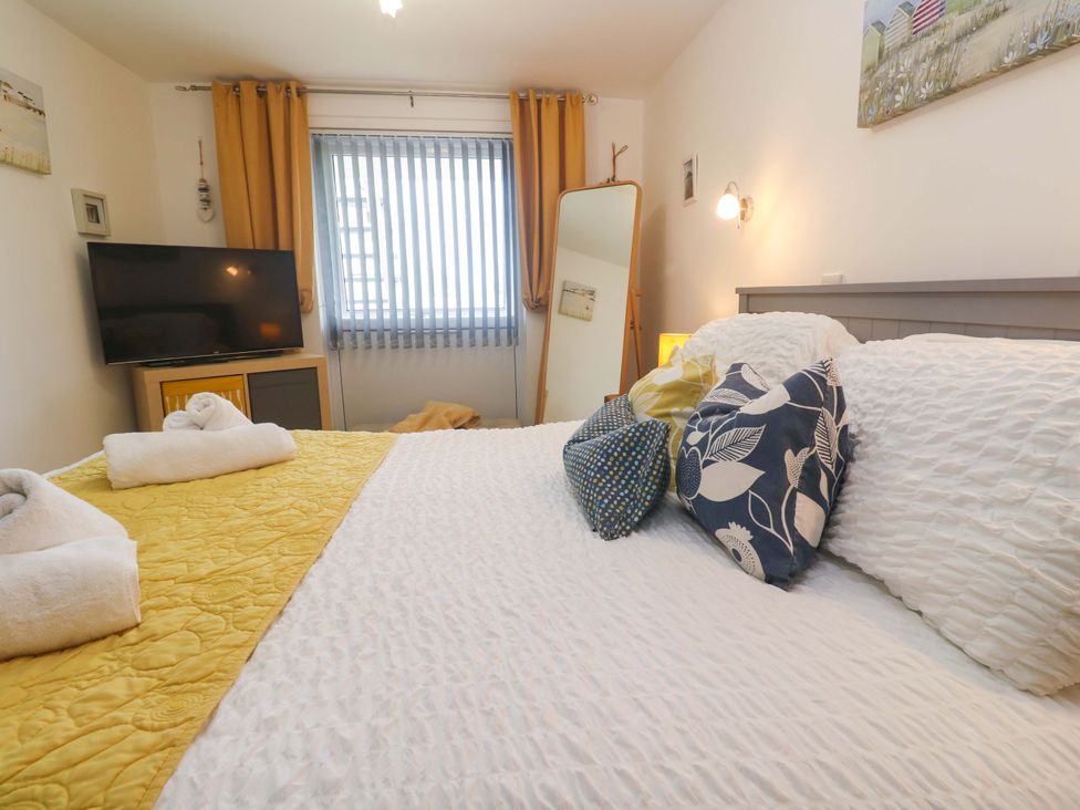 A bedroom with a bed and television at Driftwood in Marazion