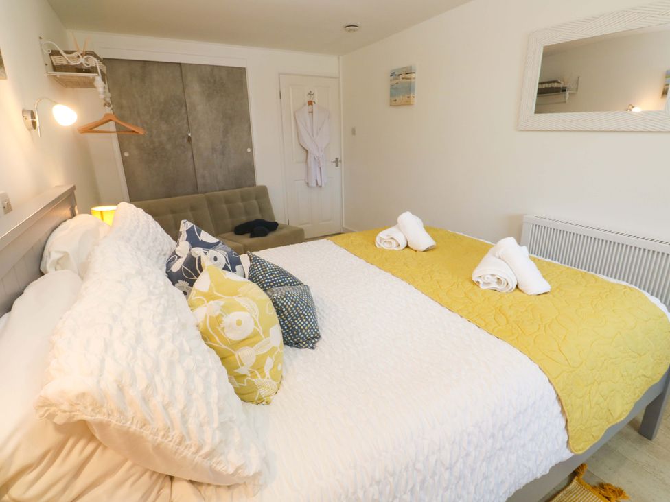 A bedroom with a double bed and seating area at Driftwood in Marazion
