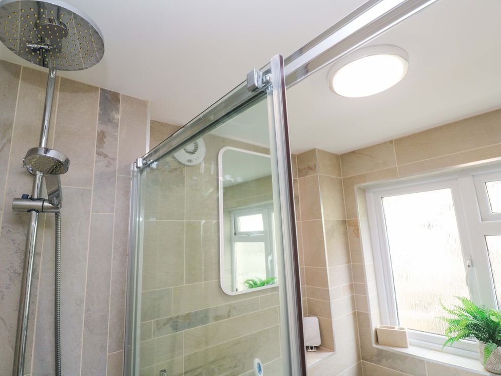 A bathroom with a shower and a window at Driftwood in Marazion