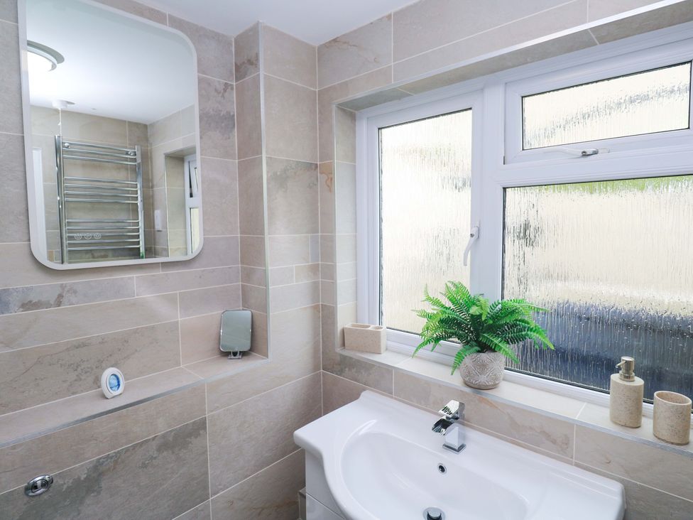 A bathroom with a sink and towel rail at Driftwood in Marazion