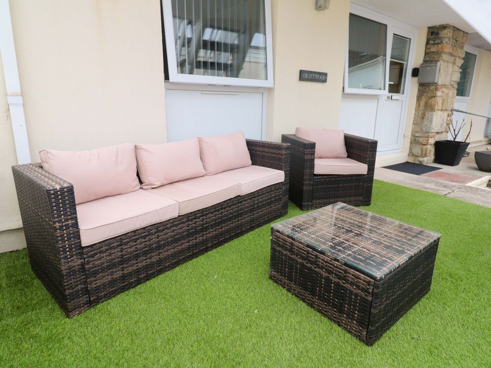 A seating area with a sofa, armchairs, and a coffee table at Driftwood in Marazion