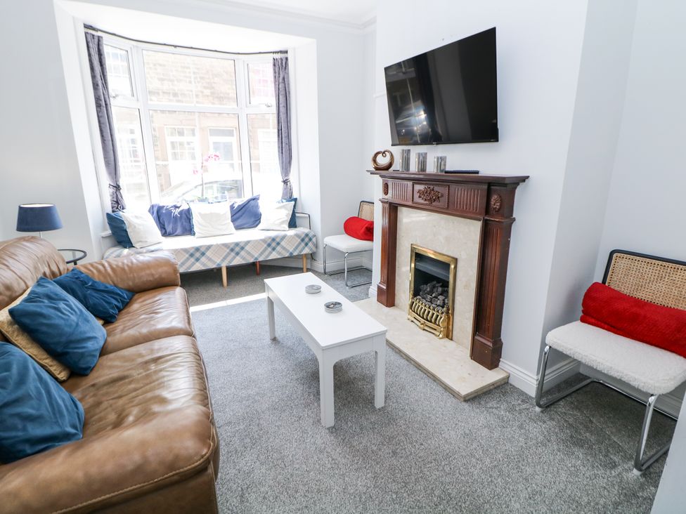 A living room with a sofa a coffee table and a television at 15 South Avenue Mews in Buxton