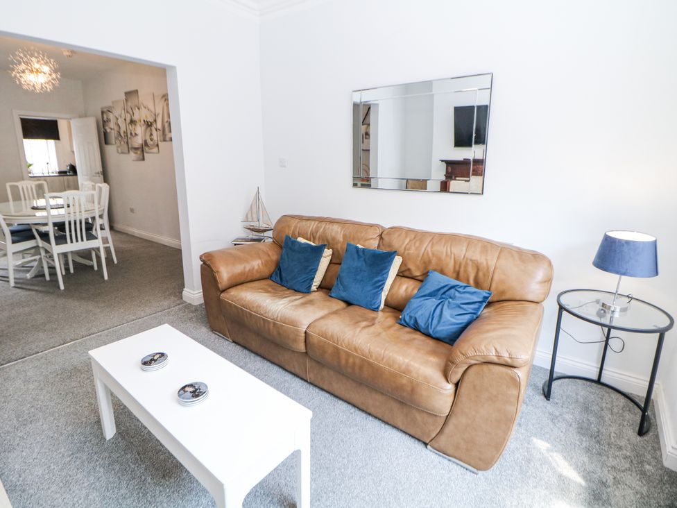 A living room with sofa and mirror at 15 South Avenue Mews Buxton