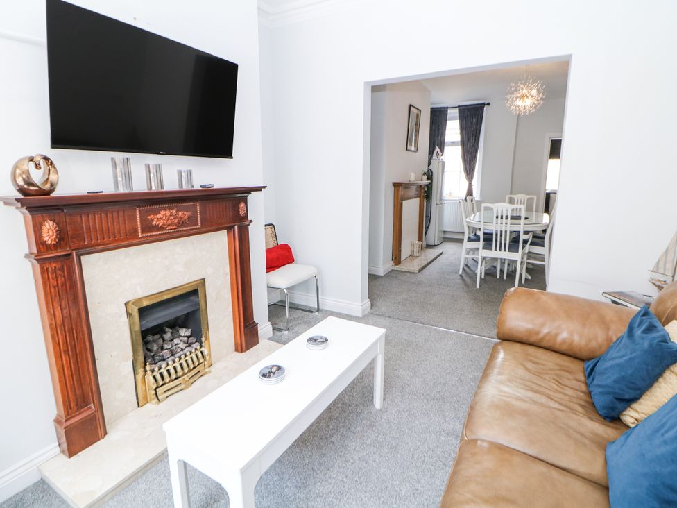 A living room with a fireplace and television at 15 South Avenue Mews Buxton