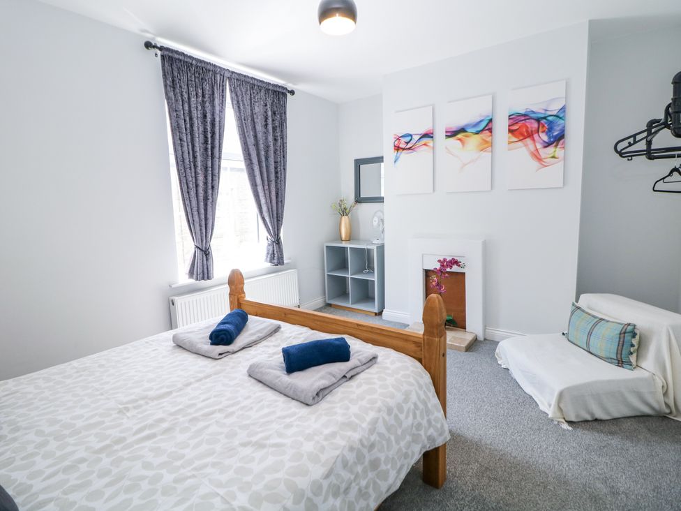 A bedroom with a bed, shelving unit, and a window at 15 South Avenue Mews Buxton