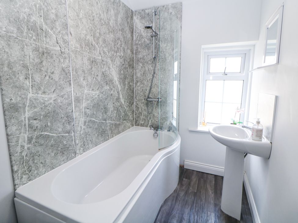 A bathroom with a bathtub and sink at 15 South Avenue Mews Buxton
