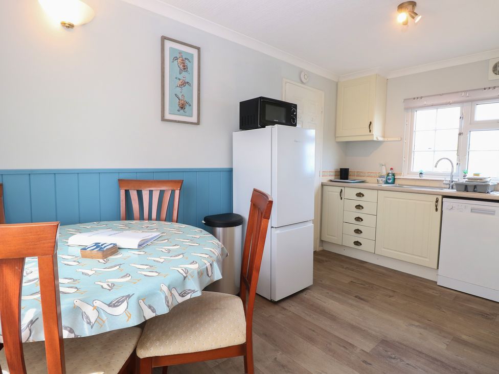 A kitchen with a table and chairs at Seaward in Trimingham