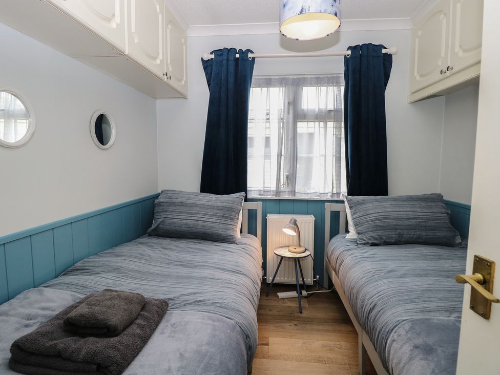 A bedroom with two beds and a lamp at Seaward in Trimingham