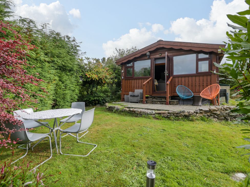 A garden with a cabin and outdoor furniture at Babbling Brook near Blaenau Ffestiniog