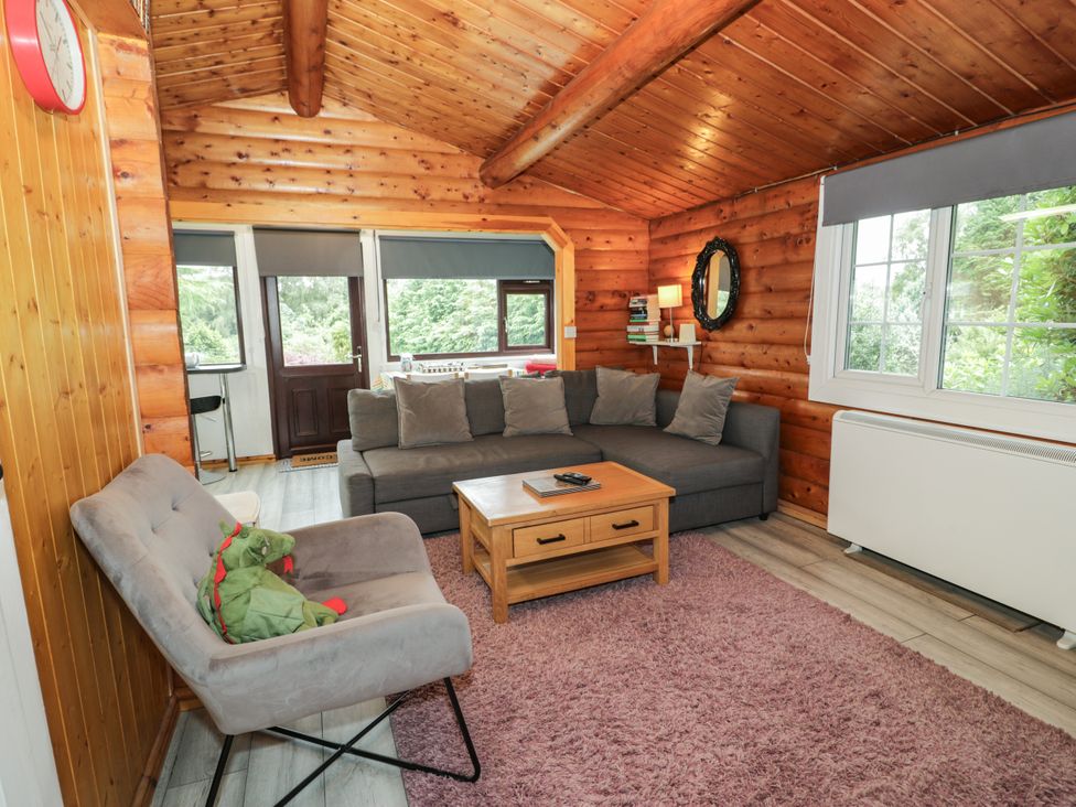 A living room with furniture and windows at Babbling Brook in Bron Aber near Blaenau Ffestiniog