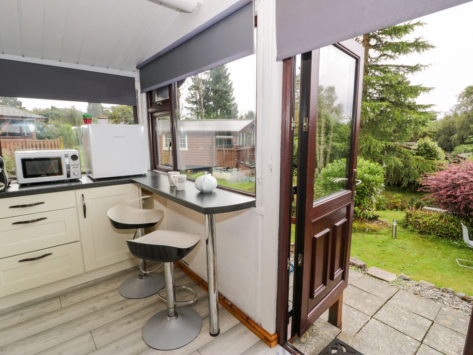 A kitchen with a microwave and fridge at Babbling Brook in Bron Aber near Blaenau Ffestiniog