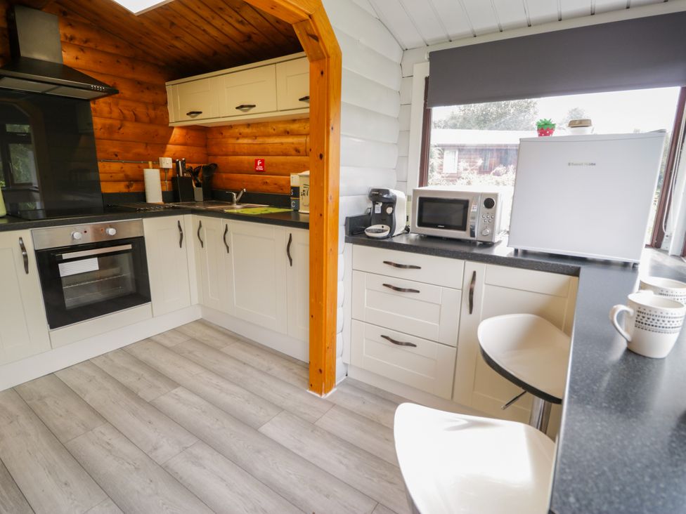 A kitchen with cabinets, an oven, and a refrigerator at Babbling Brook in Bron Aber near Blaenau Ffestiniog