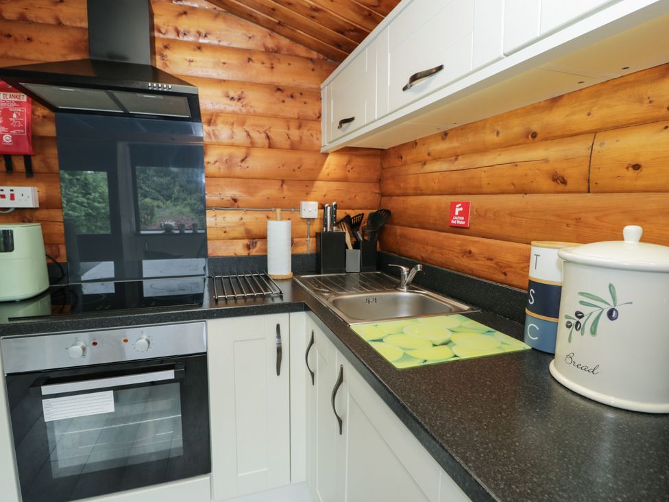 A kitchen with appliances and storage at Babbling Brook near Blaenau Ffestiniog