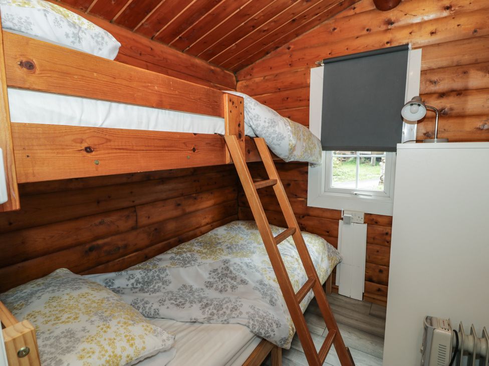 A bedroom with bunk beds and a wardrobe at Babbling Brook near Blaenau Ffestiniog