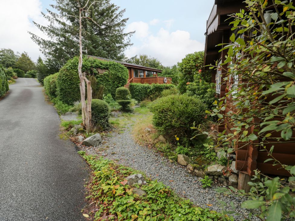 An outdoor area with gravel path and bushes at Babbling Brook in Bron Aber near Blaenau Ffestiniog