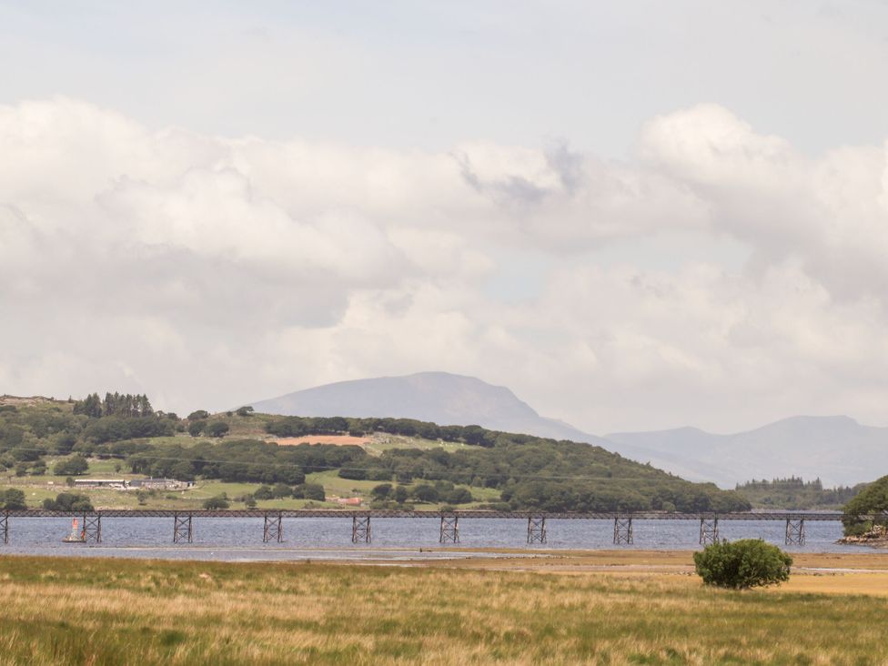 A view of a bridge over water with mountains in the background at Babbling Brook in Bron Aber near Blaenau Ffestiniog